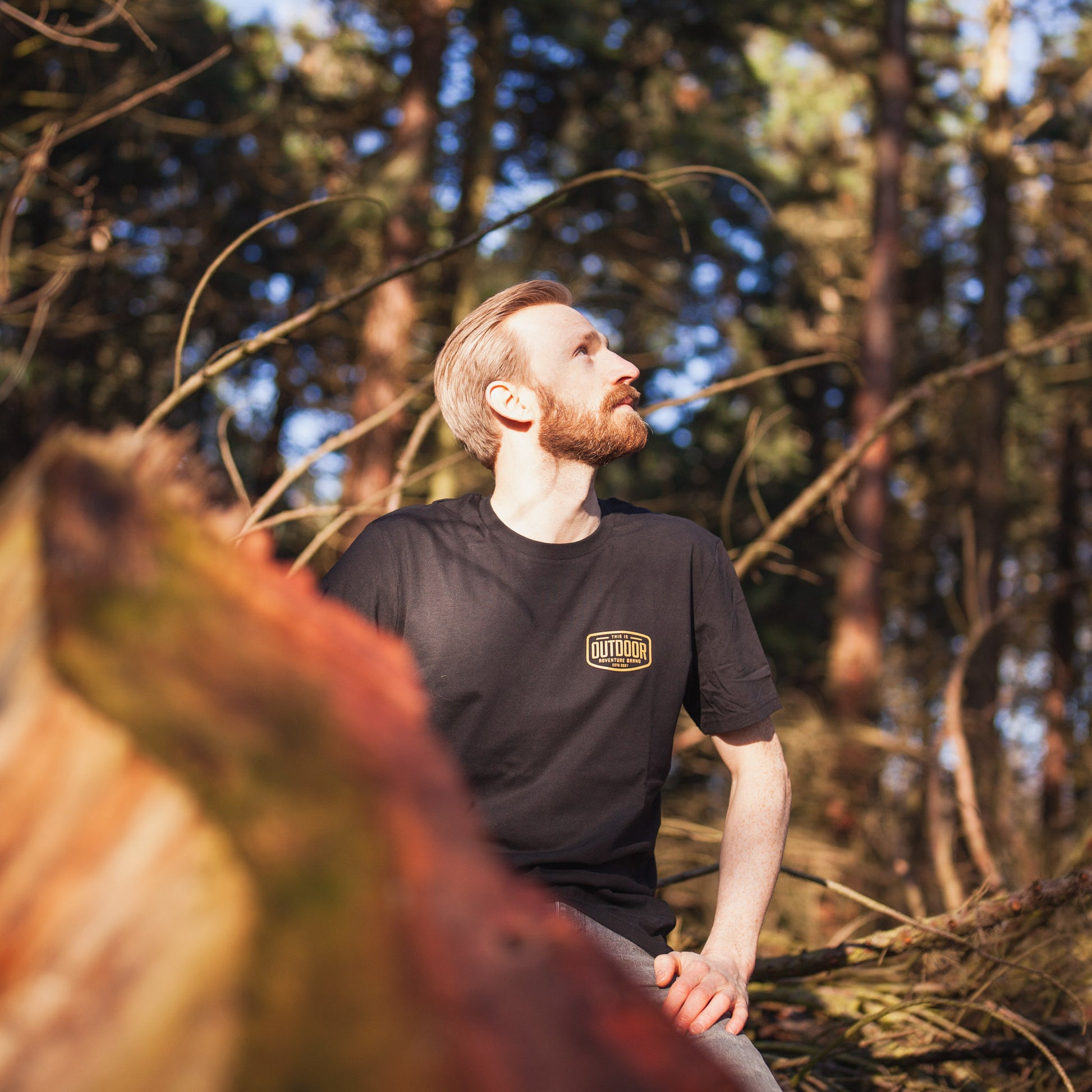 a man standing in a forest with a frisbee 