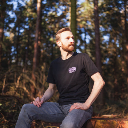 a man sitting on a bench in the woods 